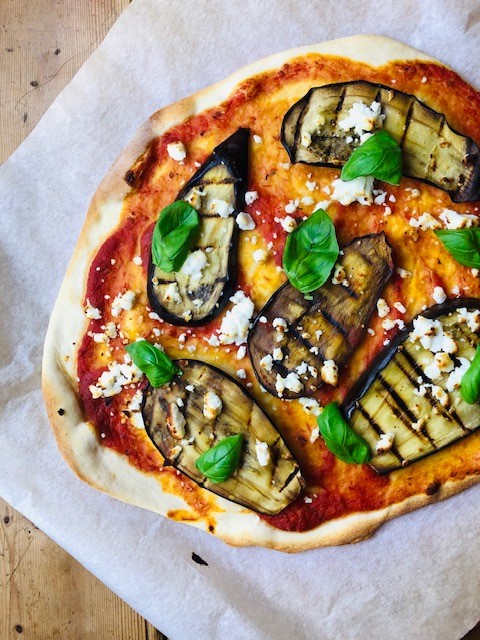 Niks lekkerder dan zelfgemaakte pizza met gegrilde aubergine, geitenkaas en basilicum. Met zelfgemaakte pizzabodem. Een heerlijke vegetarisch pizza recept.
